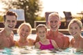 Portrait Of Smiling Multi-Generation Family On Summer Holiday Relaxing In Swimming Pool Royalty Free Stock Photo