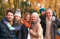 Portrait Of Smiling Multi-Generation Family Walking Along Autumn Woodland Path