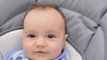 Portrait of a smiling newborn baby, close-up. A child with brown eyes looking at the camera. Face expression. Royalty Free Stock Photo