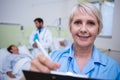 Portrait of smiling nurse writing on clipboard Royalty Free Stock Photo