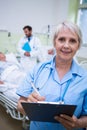 Portrait of smiling nurse writing on clipboard Royalty Free Stock Photo