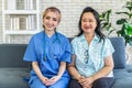 Portrait of smiling nursing home nurse in blue coat and older woman, Young friendly asian lady in medical uniform and senior Royalty Free Stock Photo