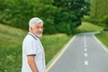 Portrait of smiling old man standing on city`s racetrack looking at camera. Royalty Free Stock Photo