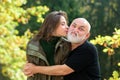 Portrait or smiling older father and grown up daughter kissing, hugging, cuddling. Two generations concept. Autumn Royalty Free Stock Photo