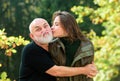 Portrait or smiling older father and grown up daughter kissing, hugging, cuddling. Two generations concept. Autumn Royalty Free Stock Photo