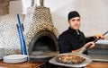 Skilled man chef preparing pizza in restaurant Royalty Free Stock Photo
