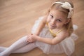 Portrait of smiling pretty diligent ballet girl sitting in white Royalty Free Stock Photo