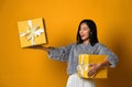 Portrait of a smiling pretty girl holding two gift boxes isolated over yellow background Royalty Free Stock Photo