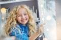 Portrait of smiling pretty little girl sits on the windowsill