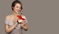 Portrait of smiling pretty woman holding a gift box heart in hands. Royalty Free Stock Photo