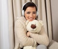 Portrait of a smiling pretty woman posing with headphones and teaddy bear Royalty Free Stock Photo