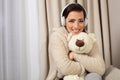 Portrait of a smiling pretty woman posing with headphones and teddy bear Royalty Free Stock Photo