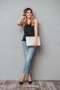 Portrait of a smiling pretty woman standing and holding laptop Royalty Free Stock Photo