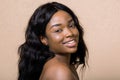 Portrait of smiling pretty young african american woman with natural makeup and long dark hair, looking at camera Royalty Free Stock Photo