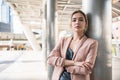 Portrait of smiling pretty young business woman with arms crossed on office background Royalty Free Stock Photo