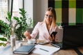 Portrait of smiling pretty young business woman in glasses sitting on workplace Royalty Free Stock Photo