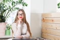 Portrait of smiling pretty young business woman in glasses sitting on workplace Royalty Free Stock Photo