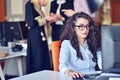 Portrait of smiling pretty young business woman in glasses sitting on workplace Royalty Free Stock Photo