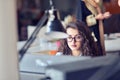 Portrait of smiling pretty young business woman in glasses sitting on workplace Royalty Free Stock Photo