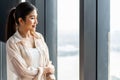 Portrait of smiling pretty young business woman standing on workplace office and looking out to window.Smile and Thinking Royalty Free Stock Photo