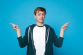 Portrait of smiling pretty young man in casual clothes pointing index fingers aside standing isolated on blue wall Royalty Free Stock Photo