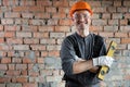 Portrait of a smiling professional repairman standing near the wall with a building level in his hands. Happy Royalty Free Stock Photo