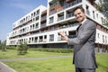 Portrait of smiling real estate agent presenting office building