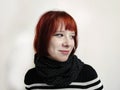 portrait of a smiling red-haired teenage girl in a black scarf on a white background Royalty Free Stock Photo