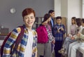 Portrait of smiling redhead boy standing with backpack in classroom Royalty Free Stock Photo
