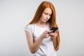 Portrait of a smiling redhead woman holding smartphone and texting Royalty Free Stock Photo