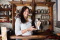 Portrait of smiling salesperson displaying tea container in store