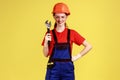 Builder woman holding adjustable wrench, looking at camera with happy facial expression. Royalty Free Stock Photo