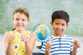 Portrait of smiling school kids showing thumbs up in classroom