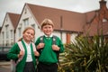 Portrait of smiling school kids standing near school building. Happy boy and girl of primary school. Royalty Free Stock Photo