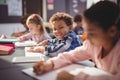 Portrait of smiling schoolboy doing his homework in classroom Royalty Free Stock Photo