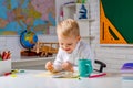 Portrait of smiling schoolboy doing his homework in classroom at school, Kid gets ready for school. Royalty Free Stock Photo