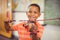 Portrait of smiling schoolboy playing violin in classroom