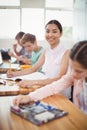 Portrait of smiling schoolgirl doing homework in classroom Royalty Free Stock Photo