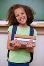 Portrait of a smiling schoolgirl holding her books