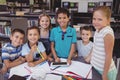 Portrait of smiling schoolkid using digital tablet in library