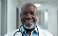 Portrait of smiling senior african american male doctor in hospital corridor, copy space Royalty Free Stock Photo