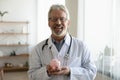 Portrait of smiling male doctor hold piggybank for charity Royalty Free Stock Photo