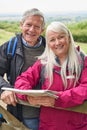 Portrait Of Smiling Senior Couple With Map Hiking In Countryside Standing By Gate Royalty Free Stock Photo
