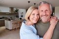 Portrait Of Smiling Senior Couple Standing At Home In Kitchen Together Royalty Free Stock Photo