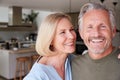 Portrait Of Smiling Senior Couple Standing At Home In Kitchen Together Royalty Free Stock Photo