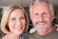 Portrait Of Smiling Senior Couple Standing At Home In Kitchen Together Royalty Free Stock Photo