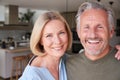 Portrait Of Smiling Senior Couple Standing At Home In Kitchen Together Royalty Free Stock Photo