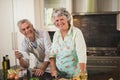 Portrait smiling senior couple standing by kitchen counter Royalty Free Stock Photo