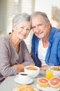 Portrait of smiling senior couple at table with breakfast Royalty Free Stock Photo