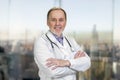 Portrait of smiling senior doctor with folded arms. Royalty Free Stock Photo